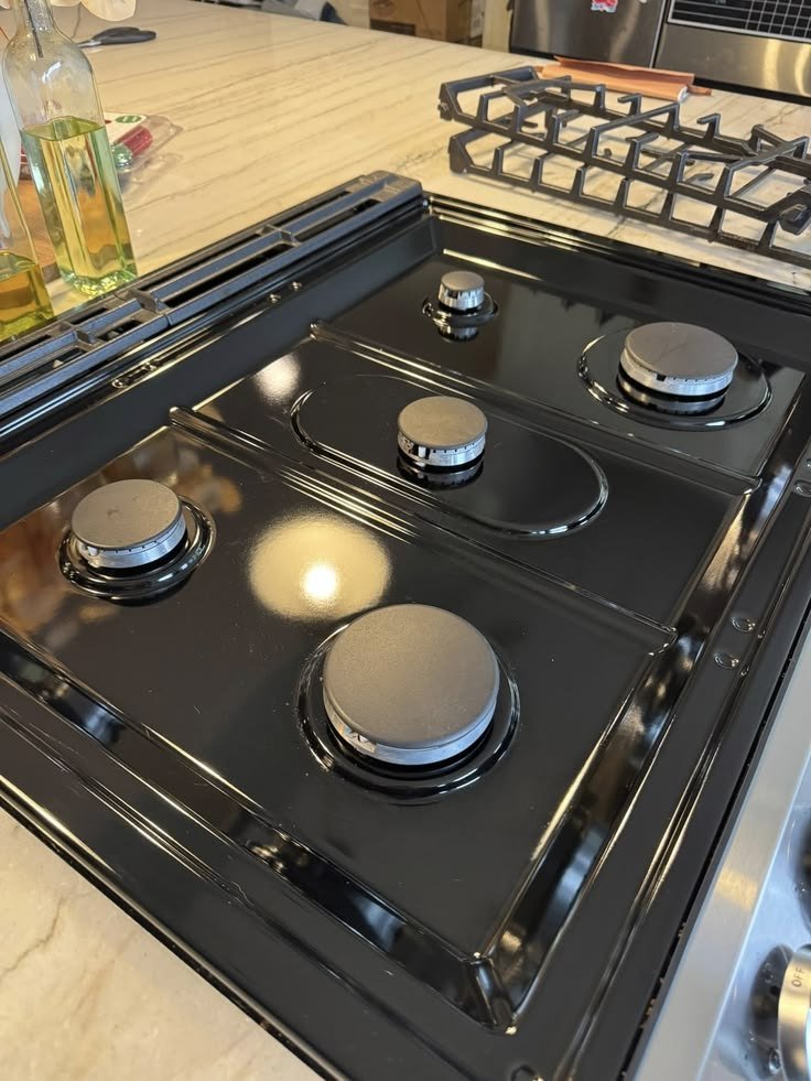 Clean black gas cooktop with polished burners