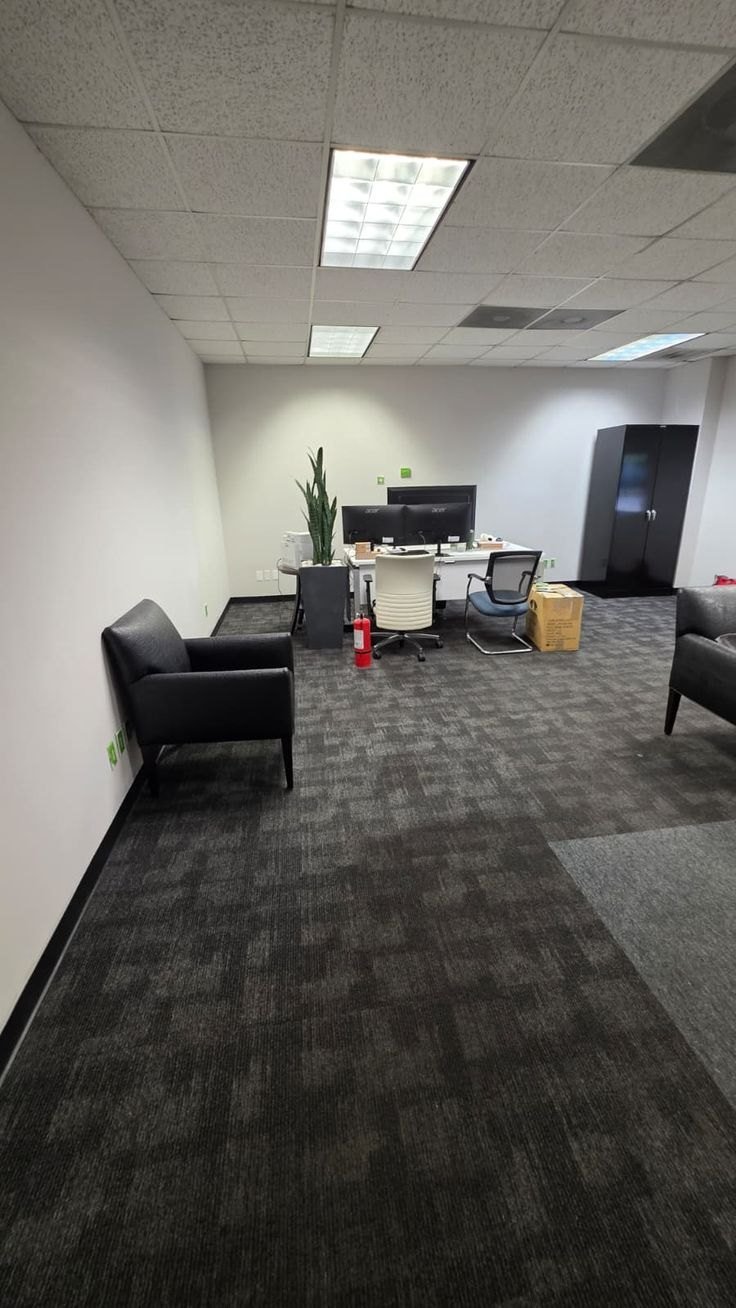 Clean office with carpet, desks and seating ready for the workday