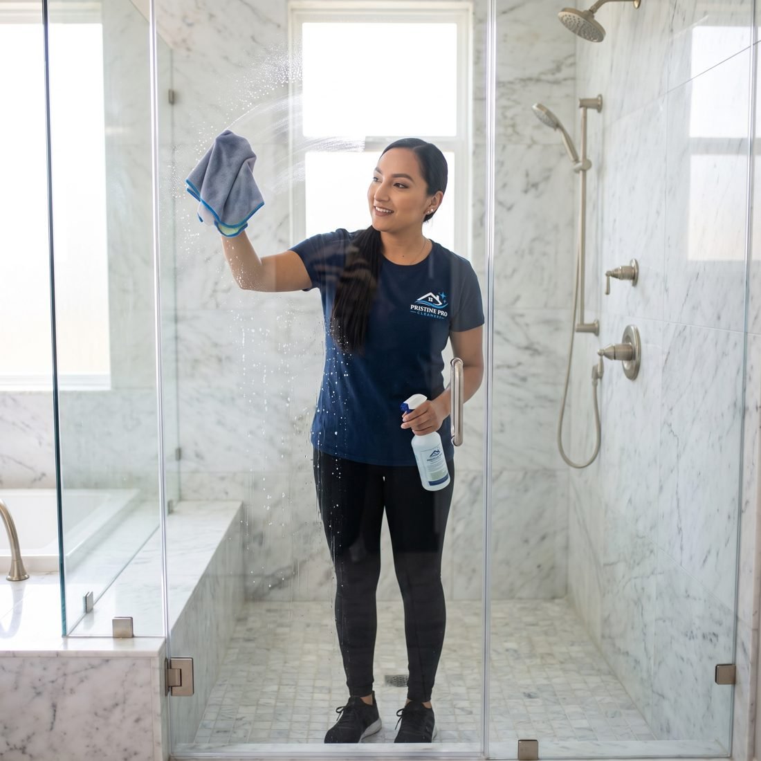 Cleaner polishing a glass shower door